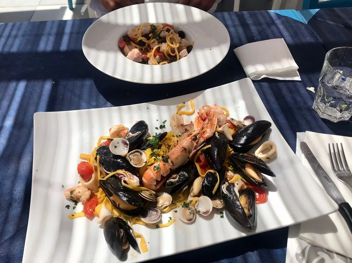 Assiette de fruits de mer sur une table dressée en bleu