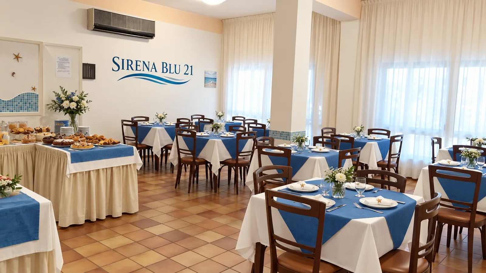 La salle du petit-déjeuner, ses tables dressées et le buffet