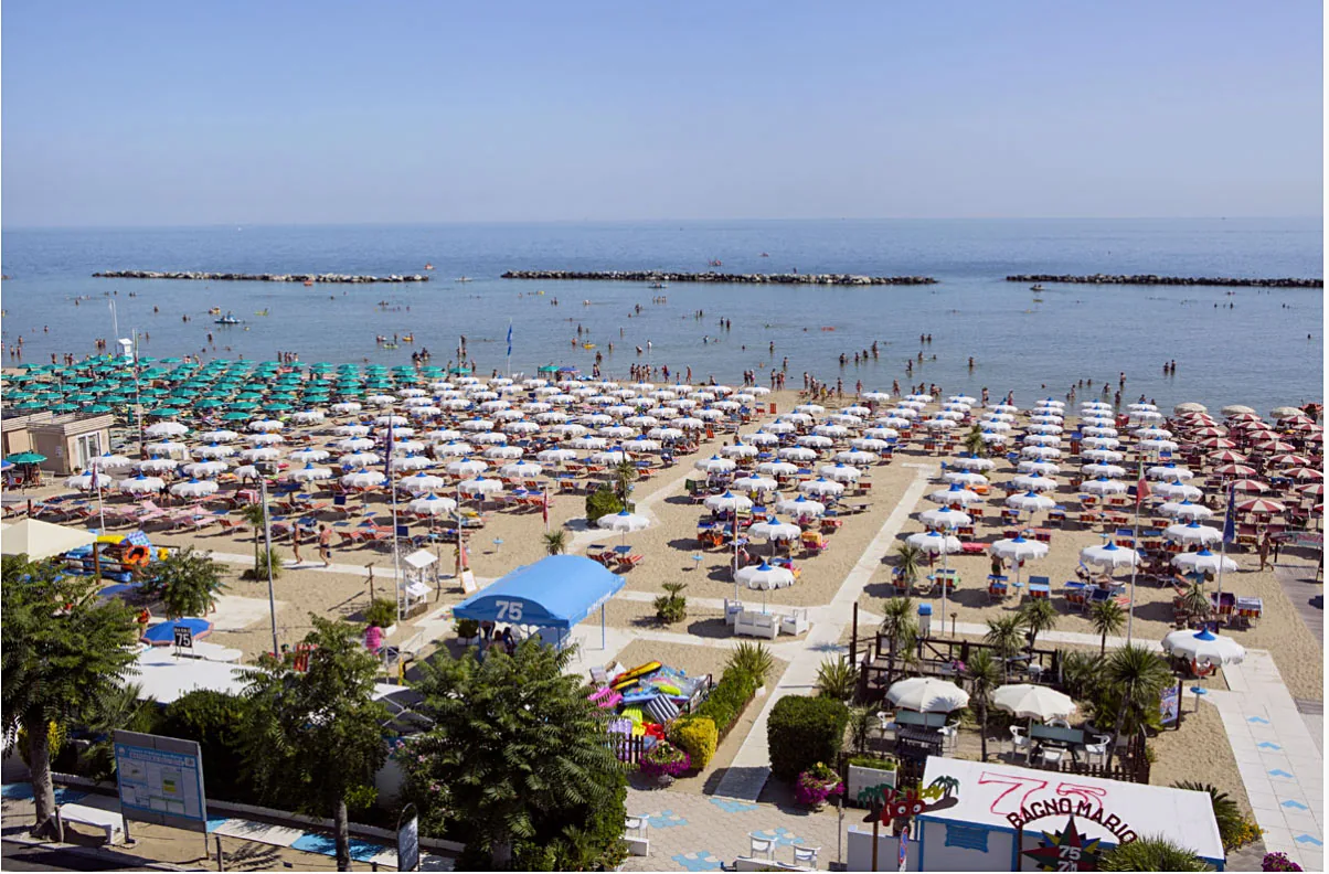Vue aérienne de la plage et de l’établissement balnéaire, avec les rangées de parasols jusqu’à la mer