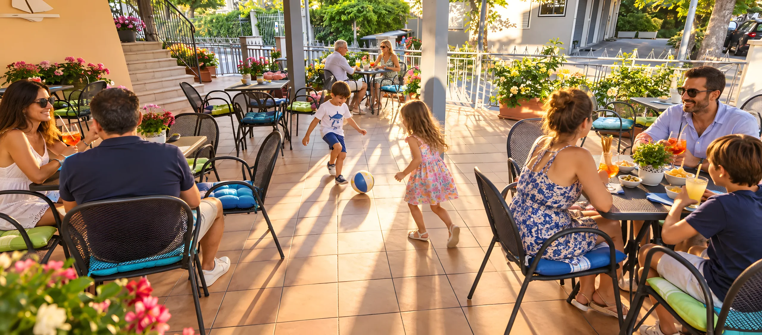 La terrasse de l’hôtel à l’heure de l’apéritif, avec des familles attablées et des enfants qui jouent
